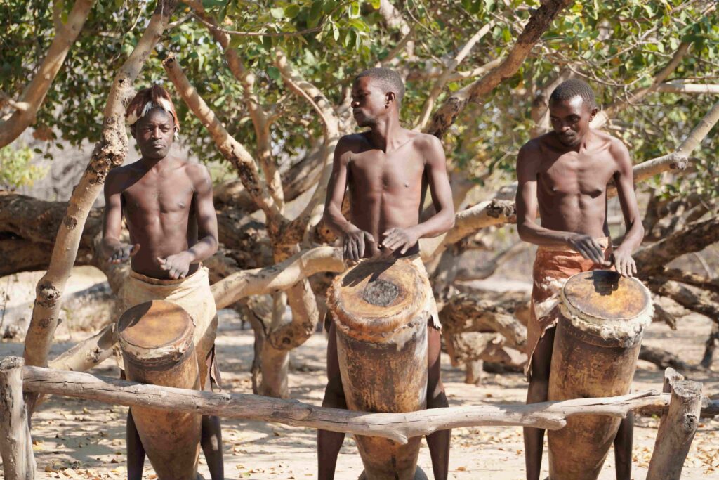 Tribal members playing on the drum 