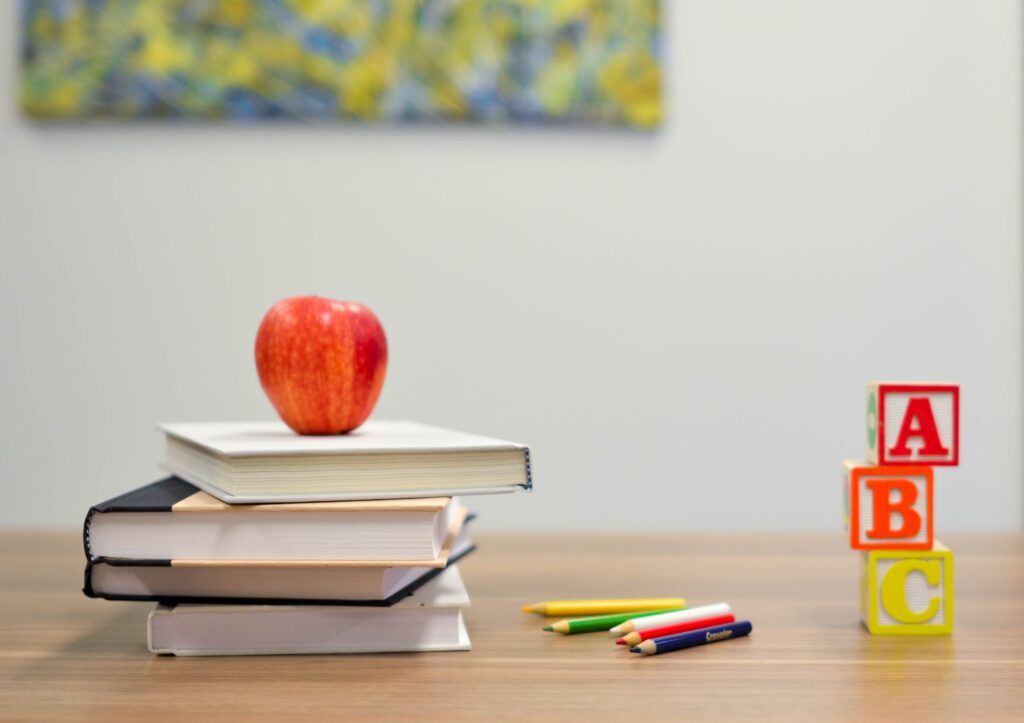 Book on the table with apple on top 